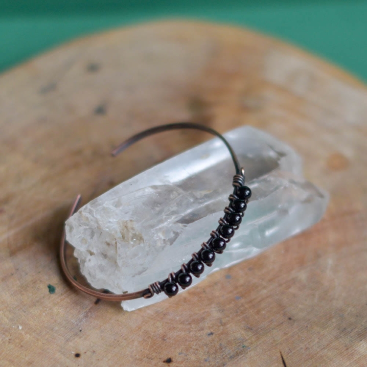 Ręcznie formowana miedź otaczająca naturalne onyksy – artystyczna bransoletka handmade